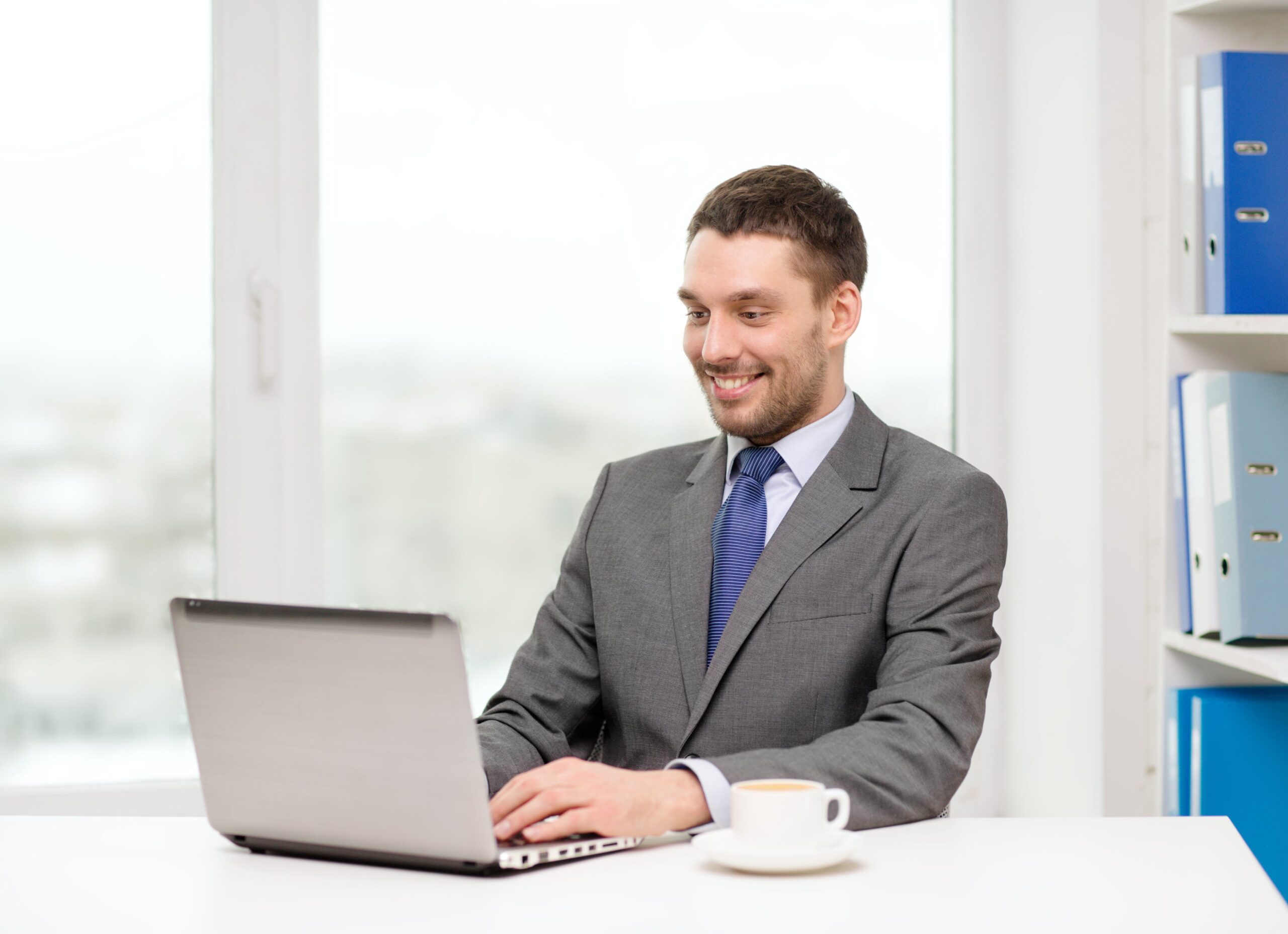 office business technology internet concept smiling businessman with laptop computer coffee office
